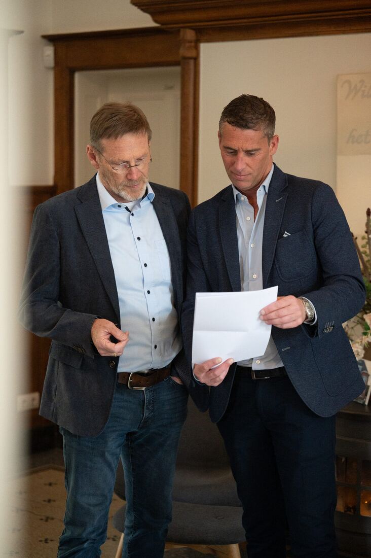 Twee experts van Schade Experts nemen samen een dossier door